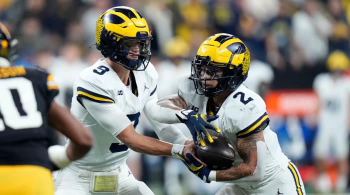 Michigan quarterback J.J. McCarthy, left, hands the ball off to running back Blake Corum.